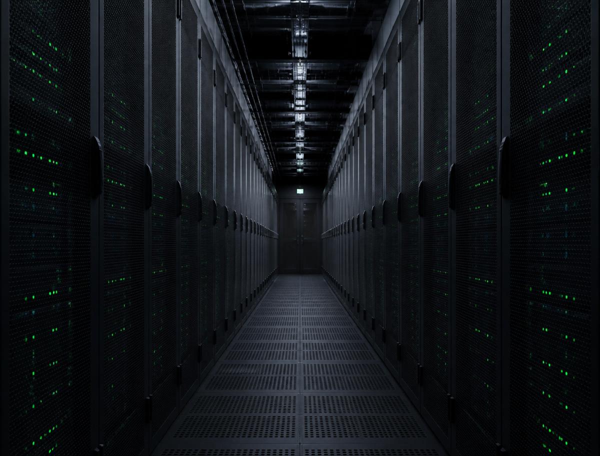 Corridor between rows of server racks in a data centre, green status lights on the cabinet doors